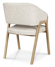 Achterkant van een moderne fauteuil met een lichte stoffen bekleding en een houten frame.