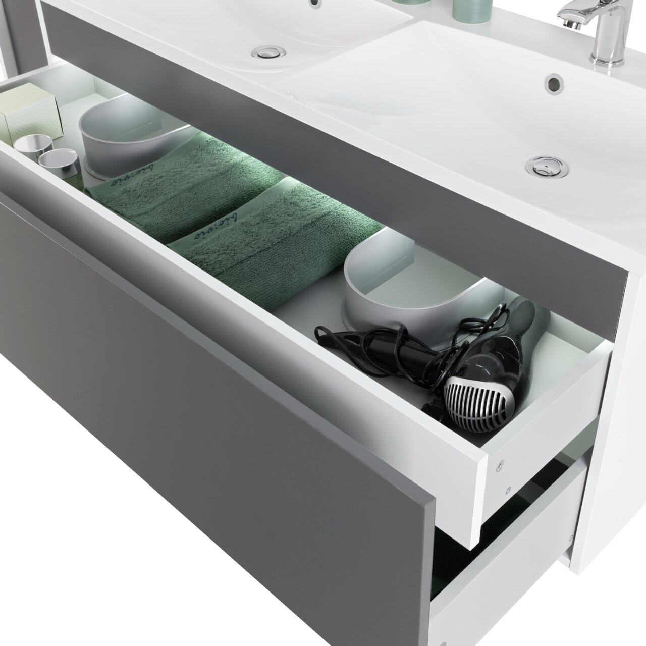 Moderner Waschplatz mit zwei Waschbecken und offener Schublade, gefüllt mit Handtüchern und einem Haartrockner, aus der Perspektive von oben.