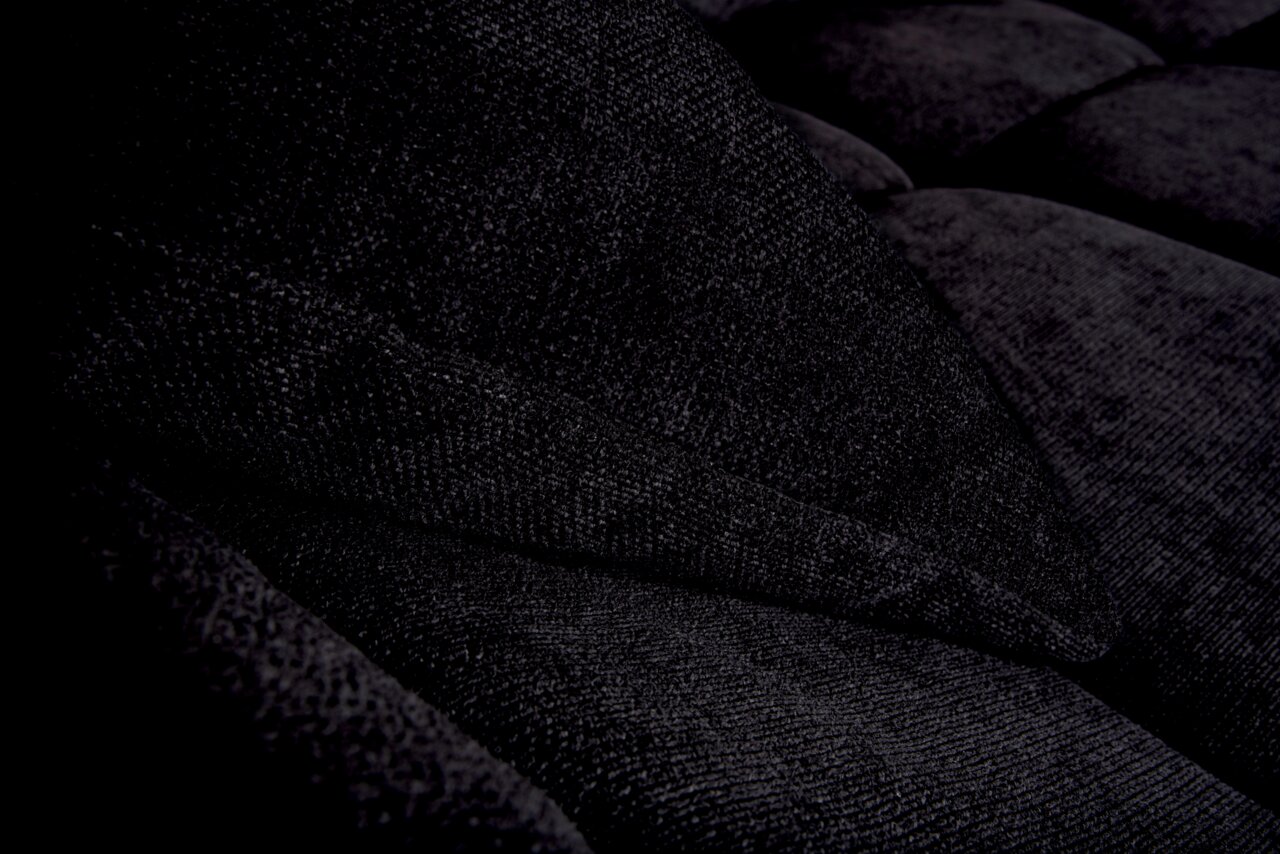 Nahaufnahme einer dunkelgrauen, strukturierten Stoffoberfläche eines Sofas mit Kissen, seitliche Perspektive.