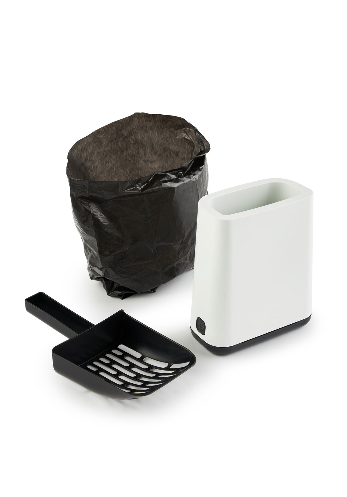 Katzenstreu Reinigungsset bestehend aus einer schwarzen Schaufel, einem weißen Behälter und einem schwarzen Beutel, aus der Vogelperspektive fotografiert.