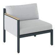 Loungebank met armleuning aan de linkerkant, grijze stoffen bekleding, zwart metalen frame, zijaanzicht