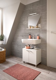 Moderne Badkombination mit Waschbecken, Spiegel und Unterschrank in einem stilvollen Badezimmer, seitliche Perspektive.