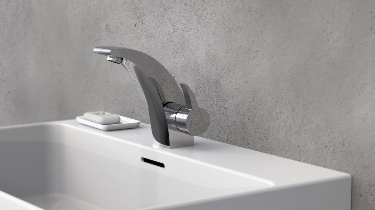 Moderne Waschtischarmatur aus Chrom in seitlicher Perspektive, montiert auf einem weißen Waschbecken vor einer grauen Wand.