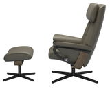 Seitliche Ansicht eines modernen Einzelsessels mit passendem Hocker in olivgrünem Leder und schwarzem Metallgestell.