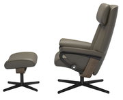 Seitliche Ansicht eines modernen Einzelsessels mit passendem Hocker in olivgrünem Leder und schwarzem Metallgestell.