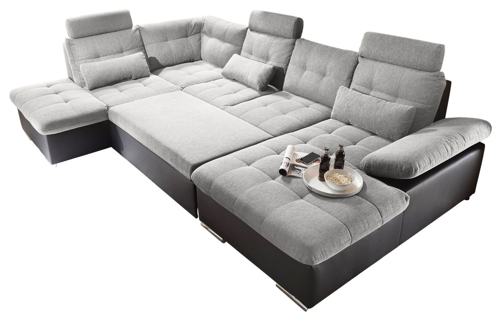 Großes, modernes Ecksofa in U-Form mit grauem Stoffbezug und schwarzen Lederakzenten, aus der Vogelperspektive fotografiert. Inklusive Kopfstützen und dekorativen Kissen, ideal für geräumige Wohnzimmer.