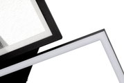 Nahaufnahme einer modernen LED-Deckenleuchte mit geometrischem Design und schwarzem Rahmen, seitliche Perspektive.