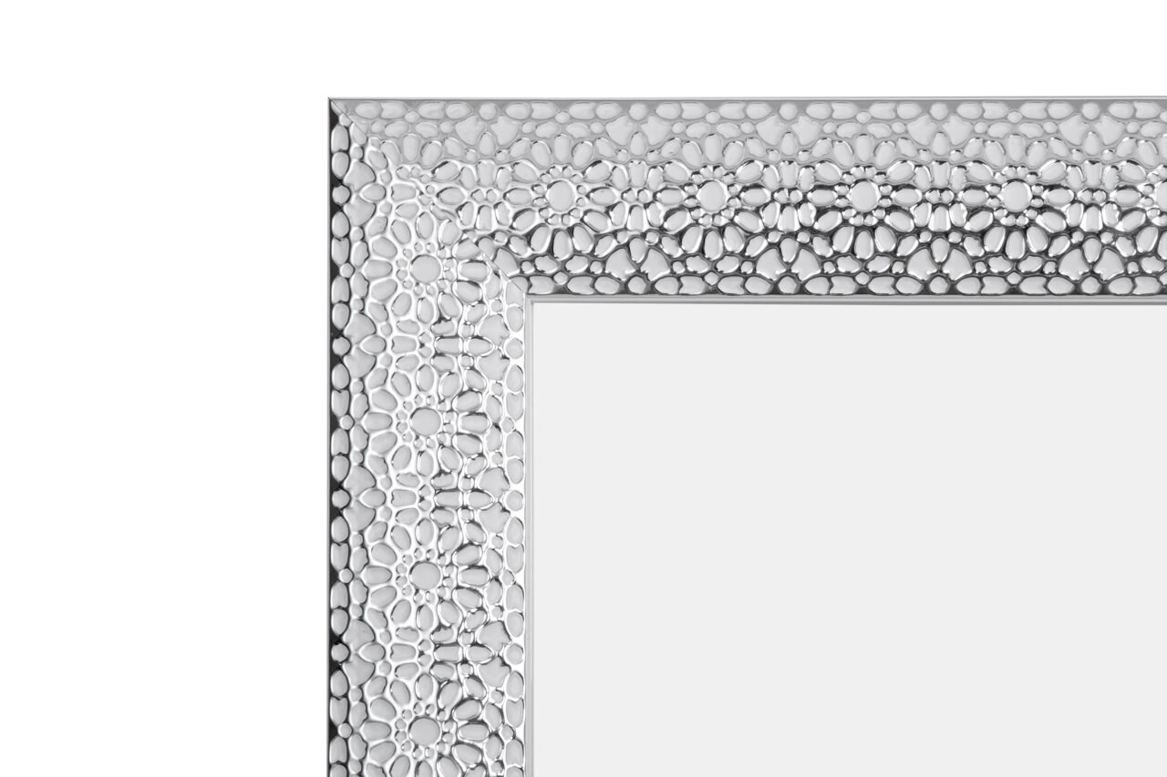 Nahaufnahme eines dekorativen Spiegels mit floralem Muster im Rahmen, Perspektive von der Ecke.