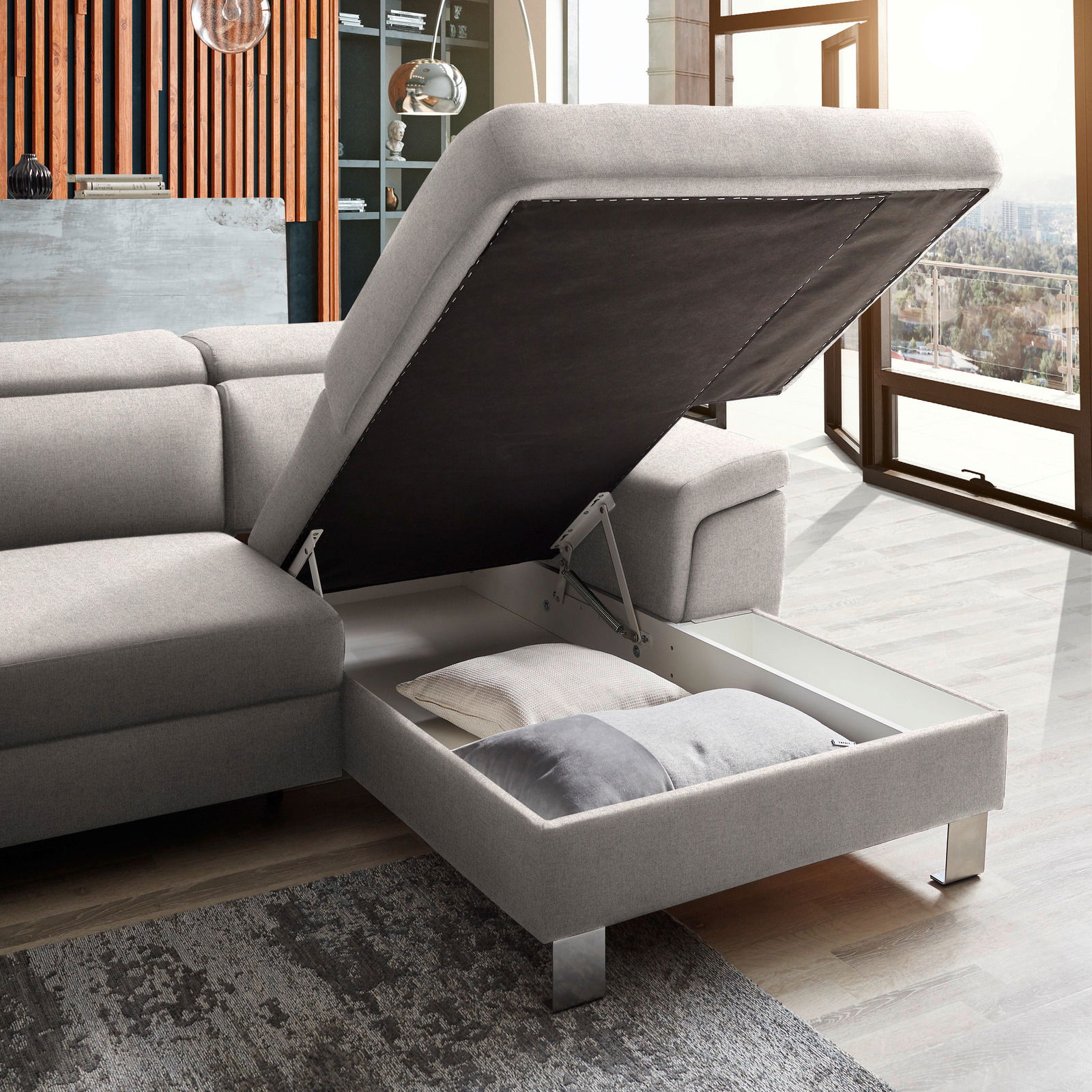 Graue Rundecke mit Stauraum, geöffnet, seitliche Perspektive, zeigt Kissen im Inneren.