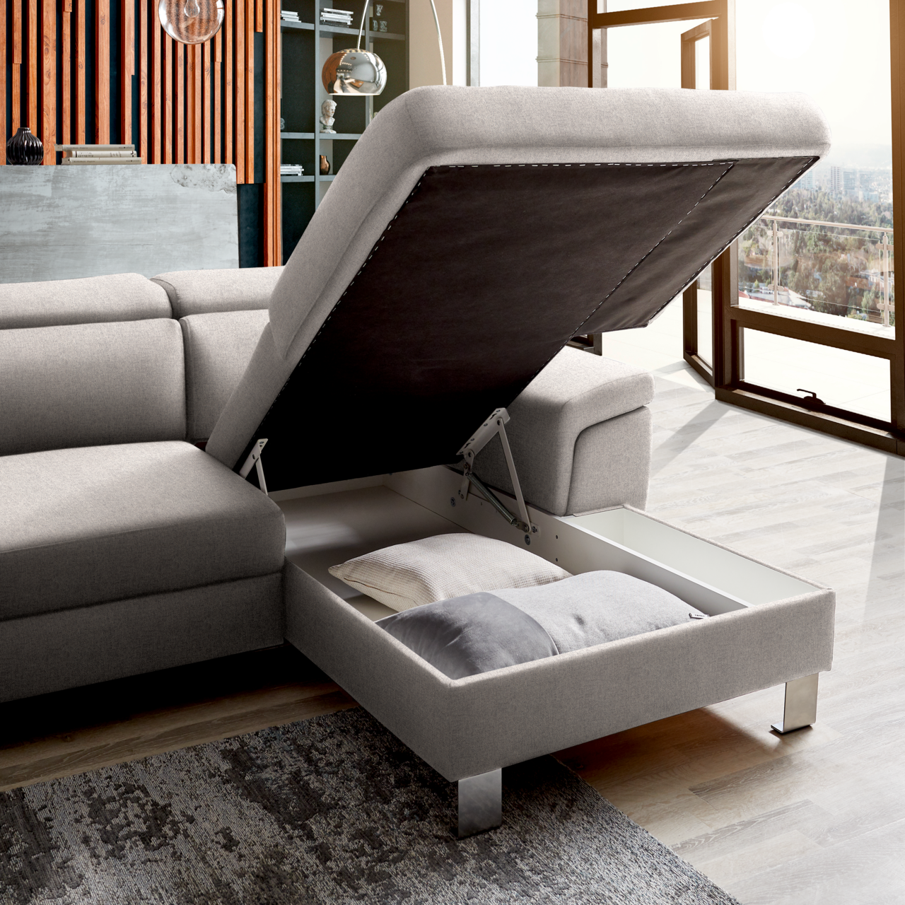 Graue Rundecke mit Stauraum, geöffnet, seitliche Perspektive, zeigt Kissen im Inneren.