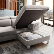 Graue Rundecke mit Stauraum, geöffnet, seitliche Perspektive, zeigt Kissen im Inneren.