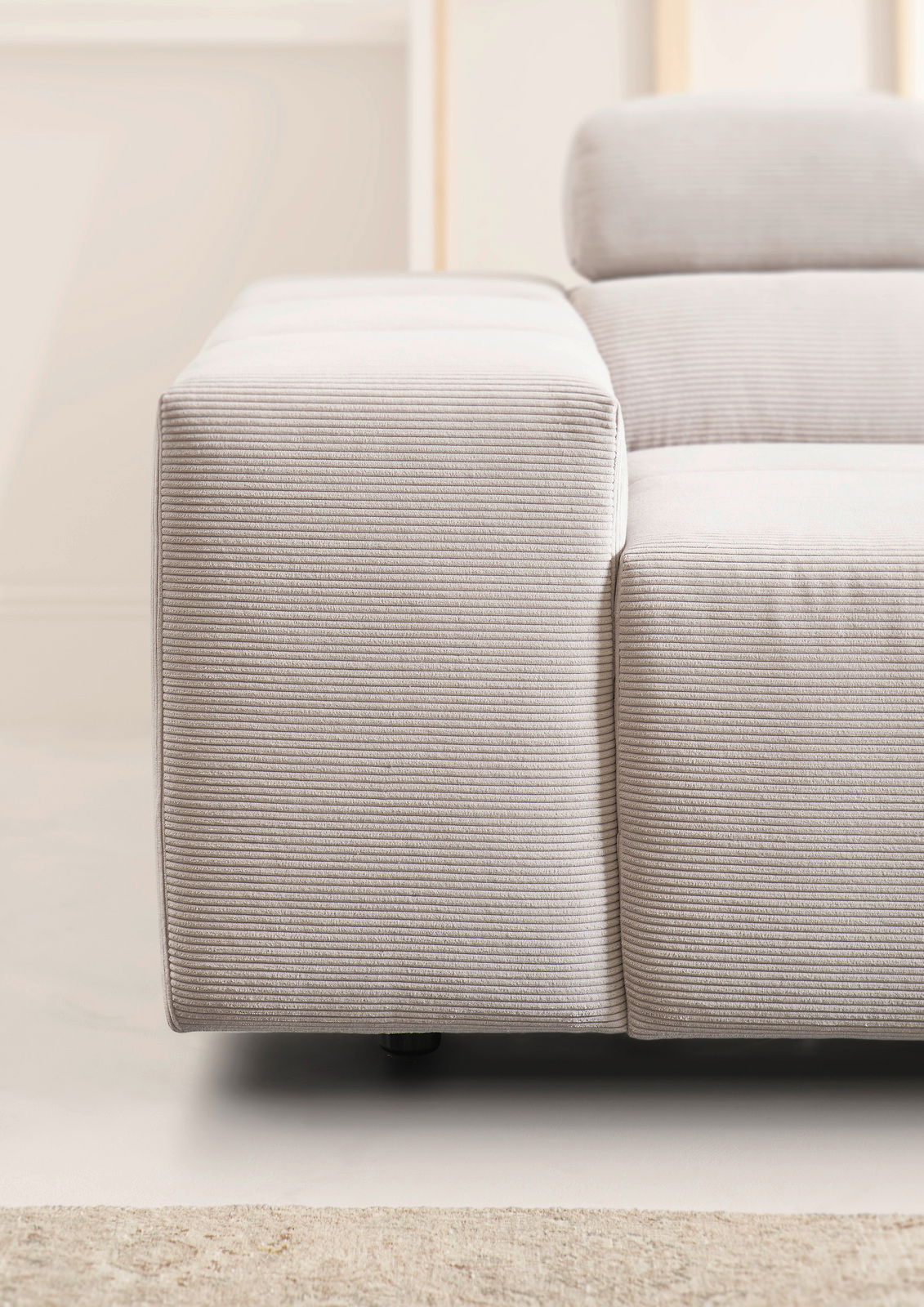 Nahaufnahme einer modernen, hellgrauen Rundecke mit feiner Streifenstruktur, seitliche Perspektive