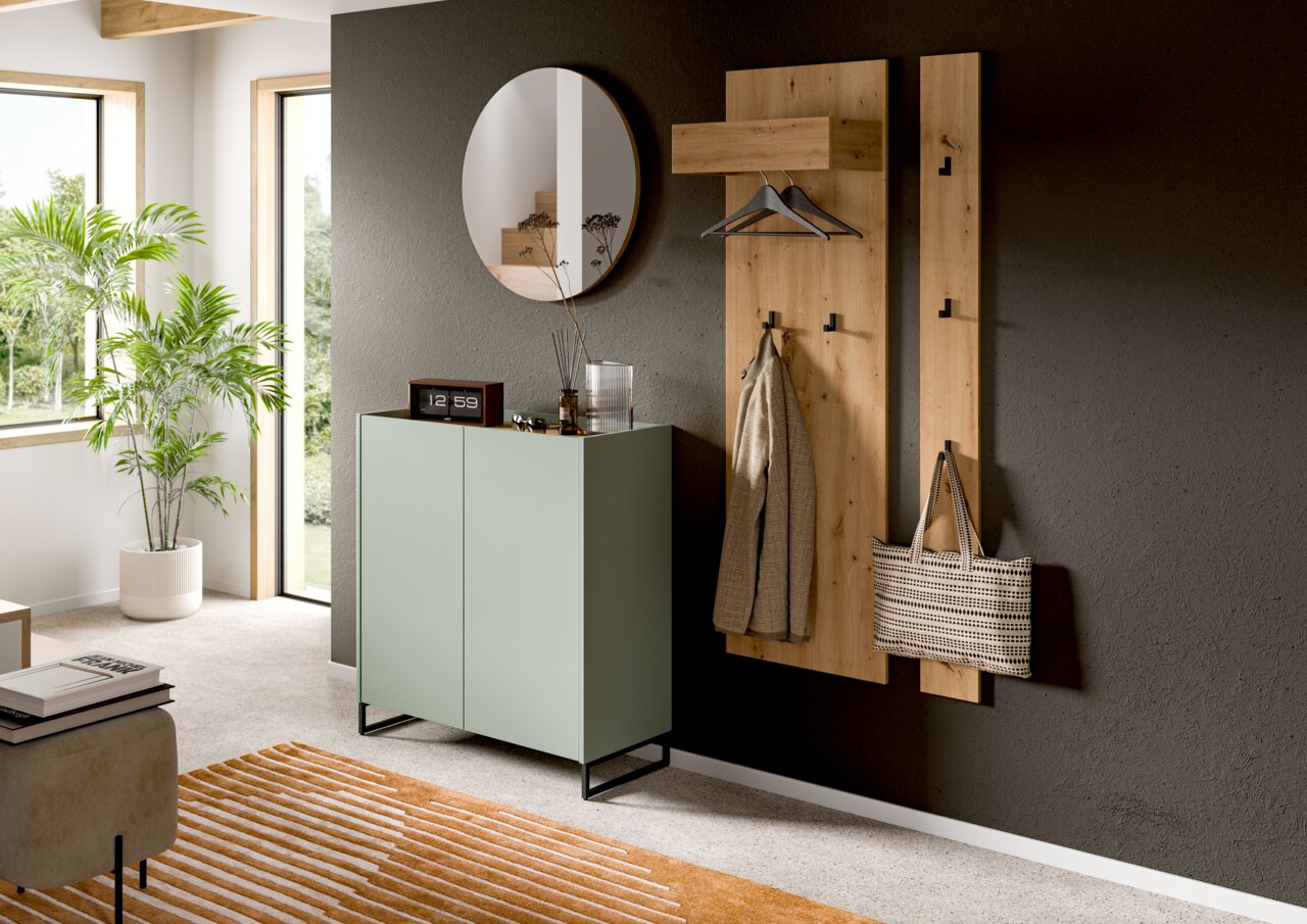 MID.YOU Schuhkommode DRIVE Modernes Garderoben-Set im Flur: zwei wandmontierte Holzpaneele mit Hutablage, Kleiderstange und Haken, daneben ein mintgrüner Schuhschrank auf schwarzem Metallgestell und runder Wandspiegel; Perspektive: frontale, leicht seitliche Ansicht.