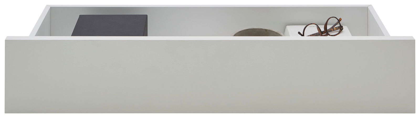 Weiße Innenschublade, frontal betrachtet, mit Gegenständen wie einer Brille und einem Buch.