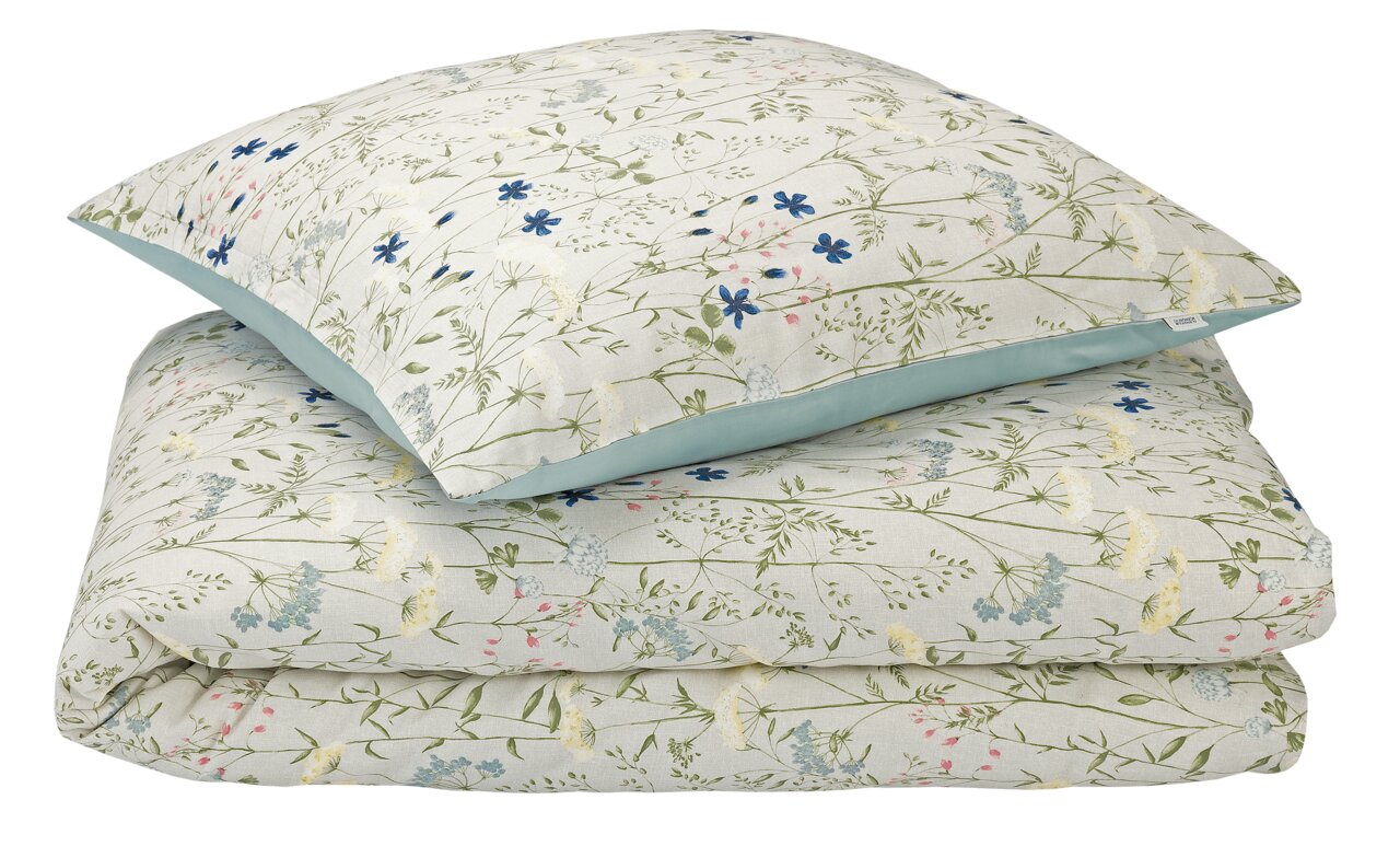 Beddengoedset met bloemmotief in pastelkleuren, bestaande uit een kussensloop en een dekbedovertrek, gefotografeerd vanuit vogelperspectief.