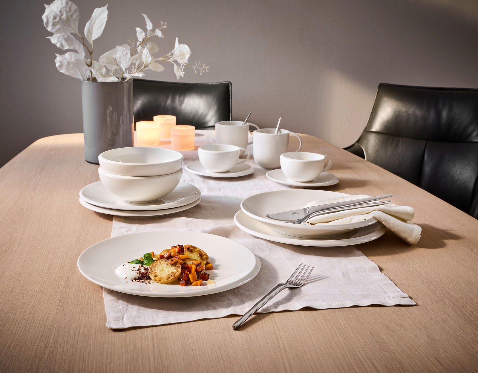 Elegantes 12-teiliges Dinner-Set auf einem gedeckten Tisch, mit einer modernen Perspektive von der Seite fotografiert.