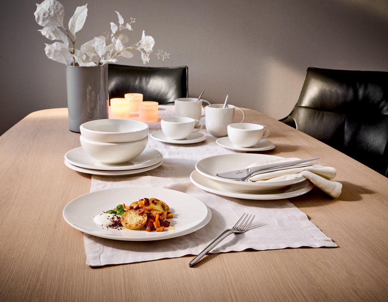 Elegantes 12-teiliges Dinner-Set auf einem gedeckten Tisch, mit einer modernen Perspektive von der Seite fotografiert.