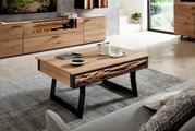 Moderne houten salontafel met een zwart metalen onderstel, versierd met een theeservies en boeken, gezien vanuit een zijdelingse hoek in een stijlvolle woonkamer.