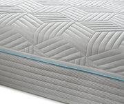 Nahaufnahme einer Gel-Kaltschaummatratze mit geometrischem Muster und blauer Ziernaht, seitliche Perspektive.