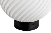 Weiße, geriffelte Tischlampe mit schwarzem Sockel und seitlichem Anschluss, Nahaufnahme aus leicht seitlicher Perspektive vor weißem Hintergrund