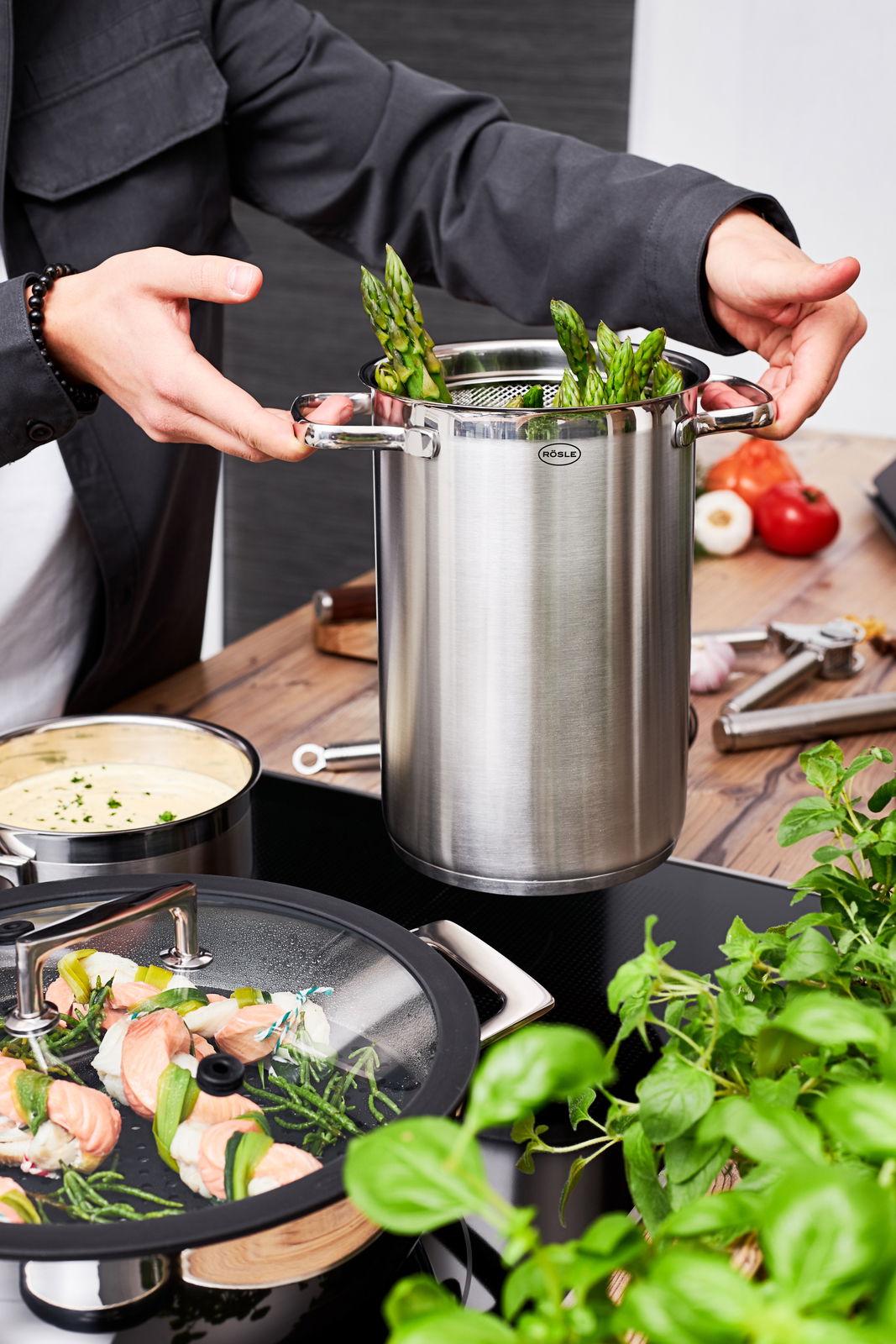 Rösle Spargel- und Pastatopf 16 cm ELEGANCE Spargel- und Pastatopf aus Edelstahl mit Einsatz, gefüllt mit grünem Spargel, in einer modernen Küchenszene von oben betrachtet.