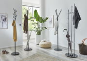 Mehrere Garderobenständer in einem modernen, hellen Raum mit Pflanzen und Dekorationen, aus seitlicher Perspektive fotografiert.