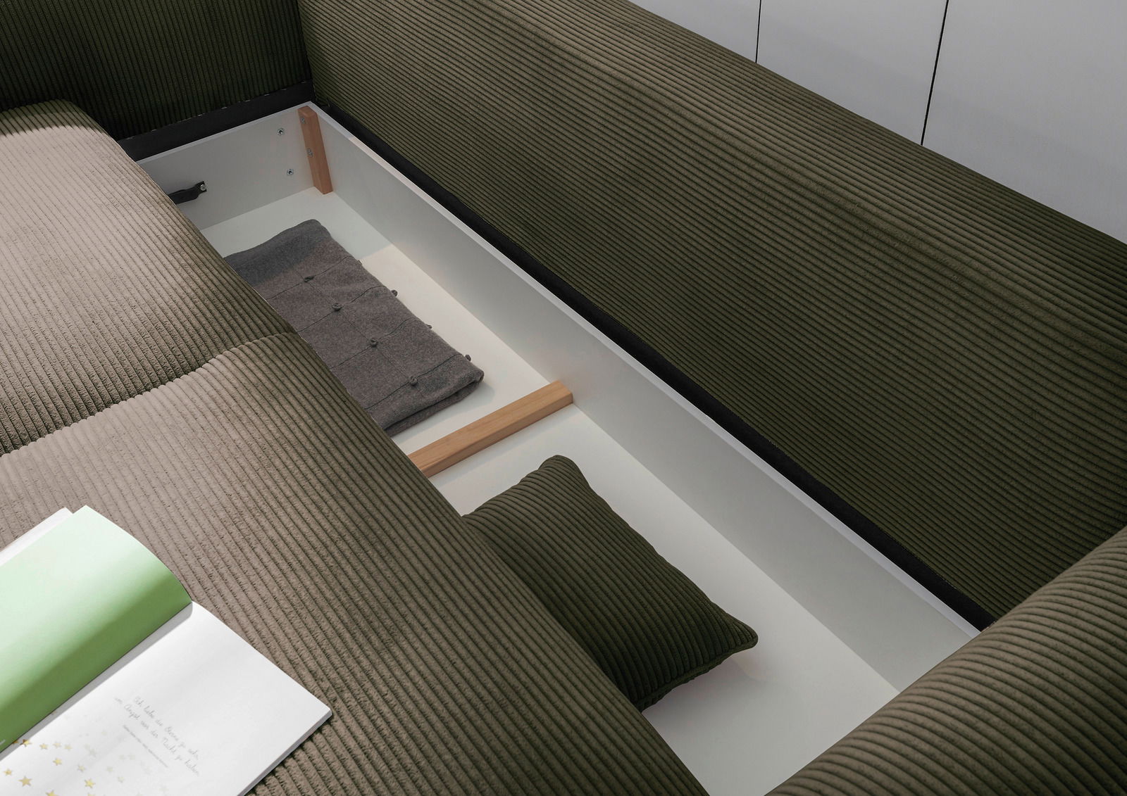 Funktionssofa mit Stauraum, Ansicht von oben, zeigt geöffnete Aufbewahrung mit Kissen und Decke.
