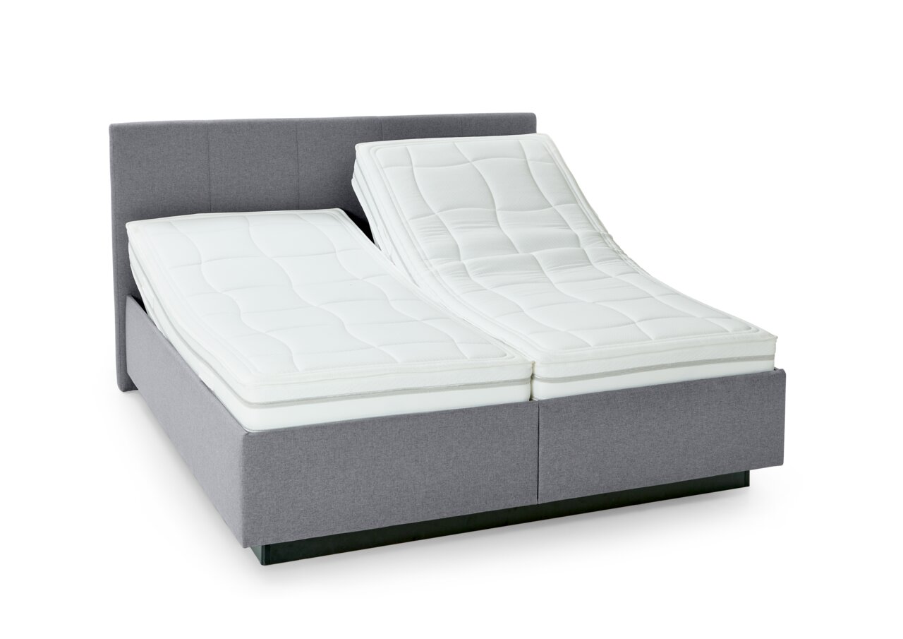 Grijs boxspringbed met verstelbare matrassen, zijaanzicht