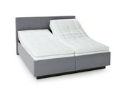 Grijs boxspringbed met verstelbare matrassen, zijaanzicht
