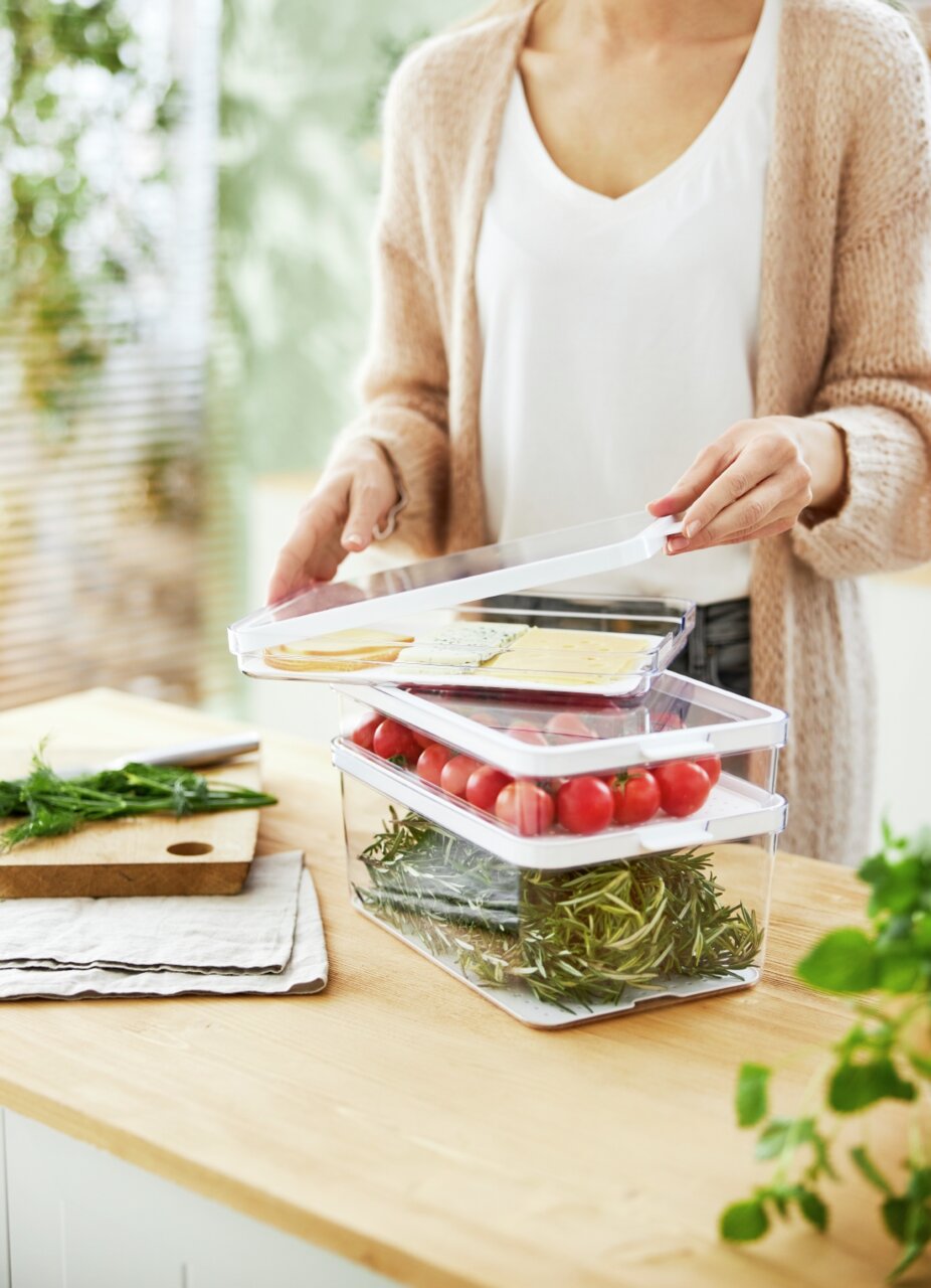 Kühlschrankorganizer 3-teilig, gefüllt mit frischen Lebensmitteln wie Tomaten und Kräutern, auf einer Küchenarbeitsplatte. Perspektive von vorne.
