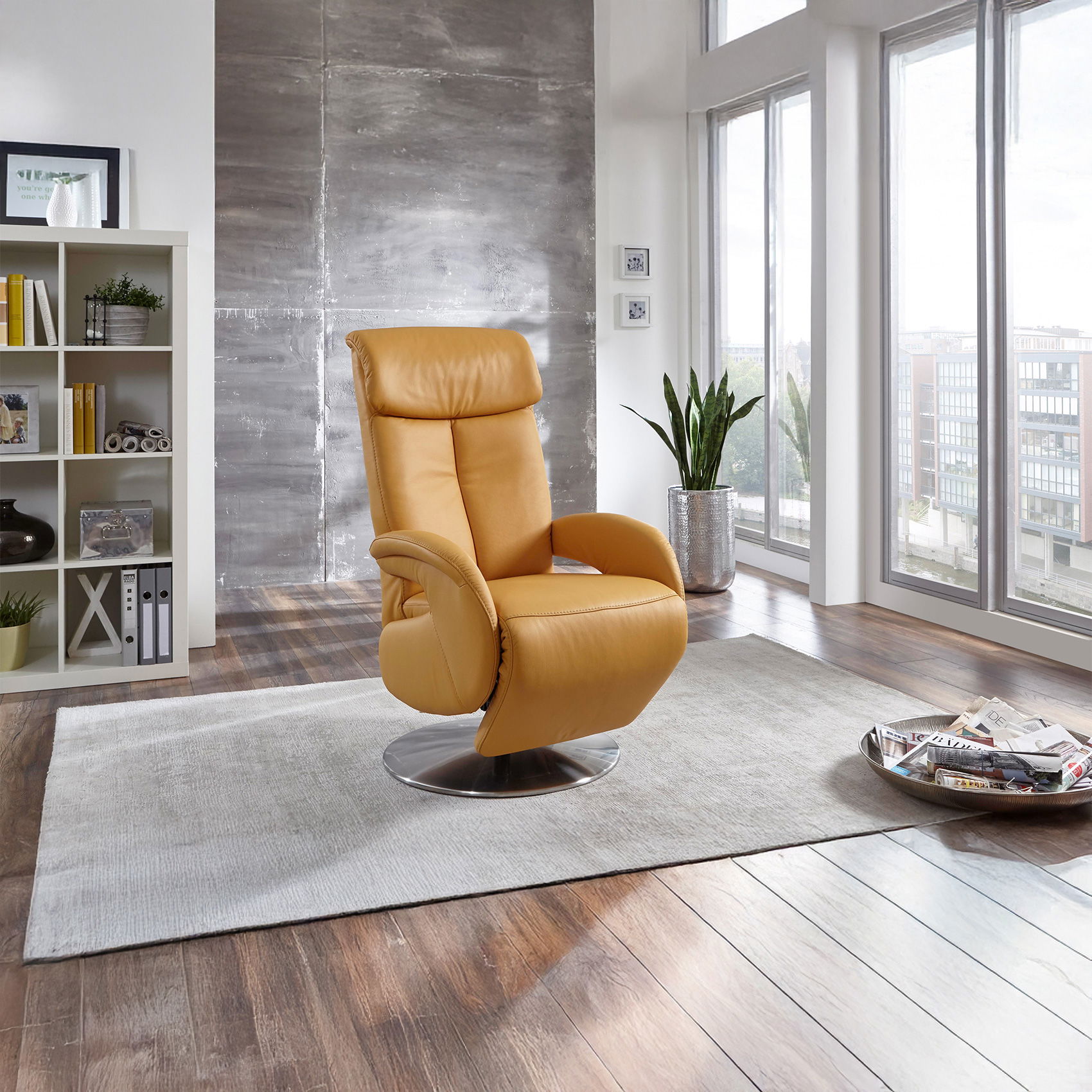 Gelber Relax-Fernsehsessel auf Teppich in modernem Wohnzimmer mit großen Fenstern und Regal