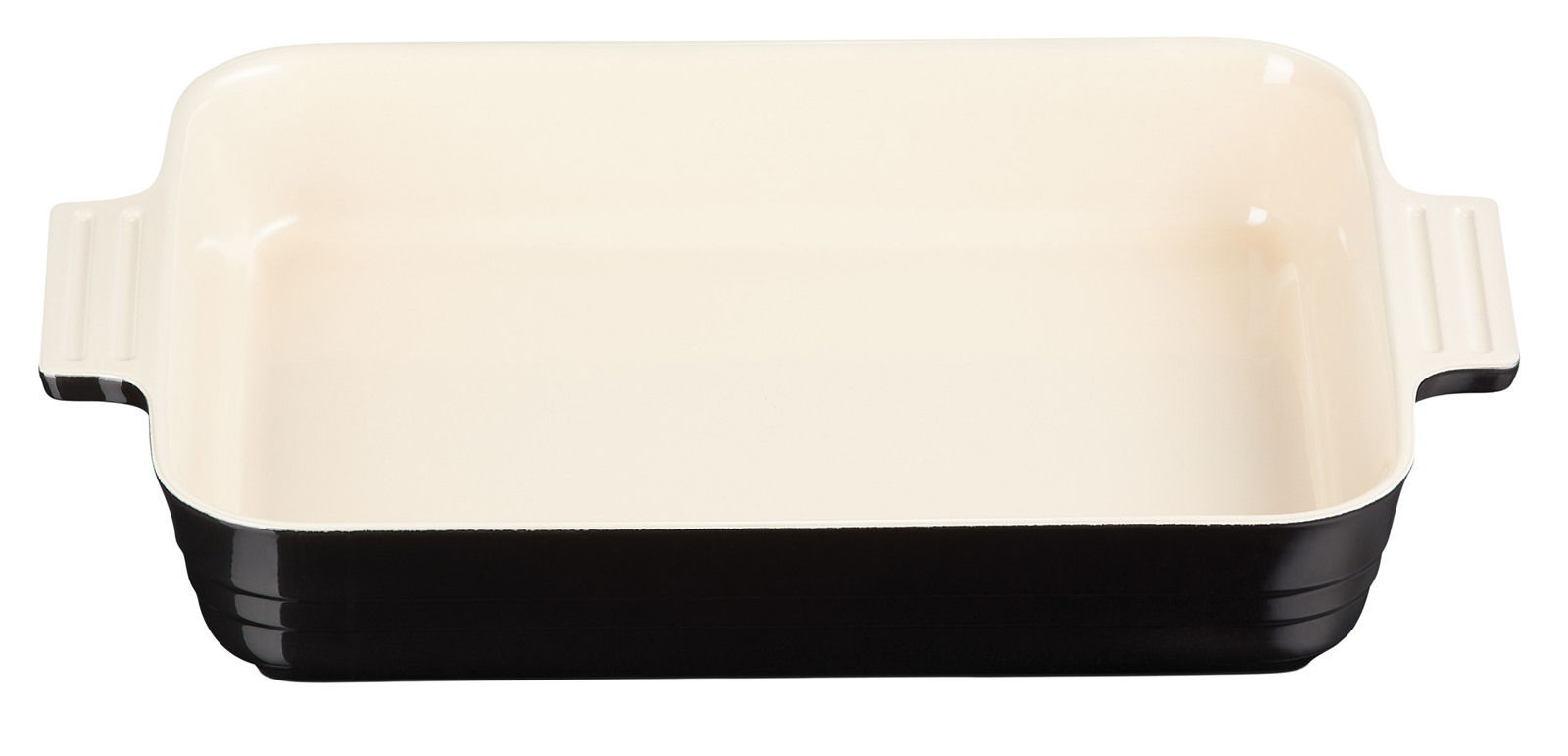 Schwarze Auflaufform mit cremefarbener Innenfläche, rechteckig, mit Griffen, aus der Vogelperspektive fotografiert.