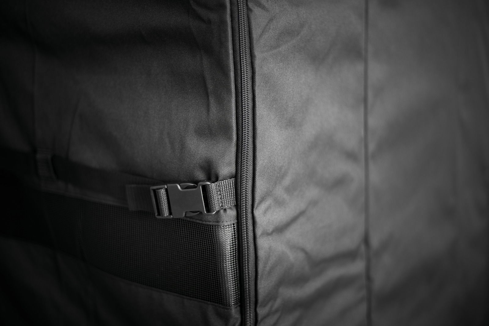 Nahaufnahme einer schwarzen Abdeckhaube mit Reißverschluss und Schnalle, seitliche Perspektive.