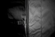 Nahaufnahme einer schwarzen Abdeckhaube mit Reißverschluss und Schnalle, seitliche Perspektive.