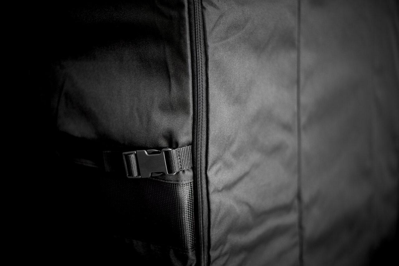 Nahaufnahme einer schwarzen Abdeckhaube mit Reißverschluss und Schnalle, seitliche Perspektive.