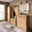 Moderne Garderobeneinrichtung aus Holz mit Spiegel, Garderobenbank, Garderobenpaneel und Schrank in einem hellen Raum, seitliche Perspektive.