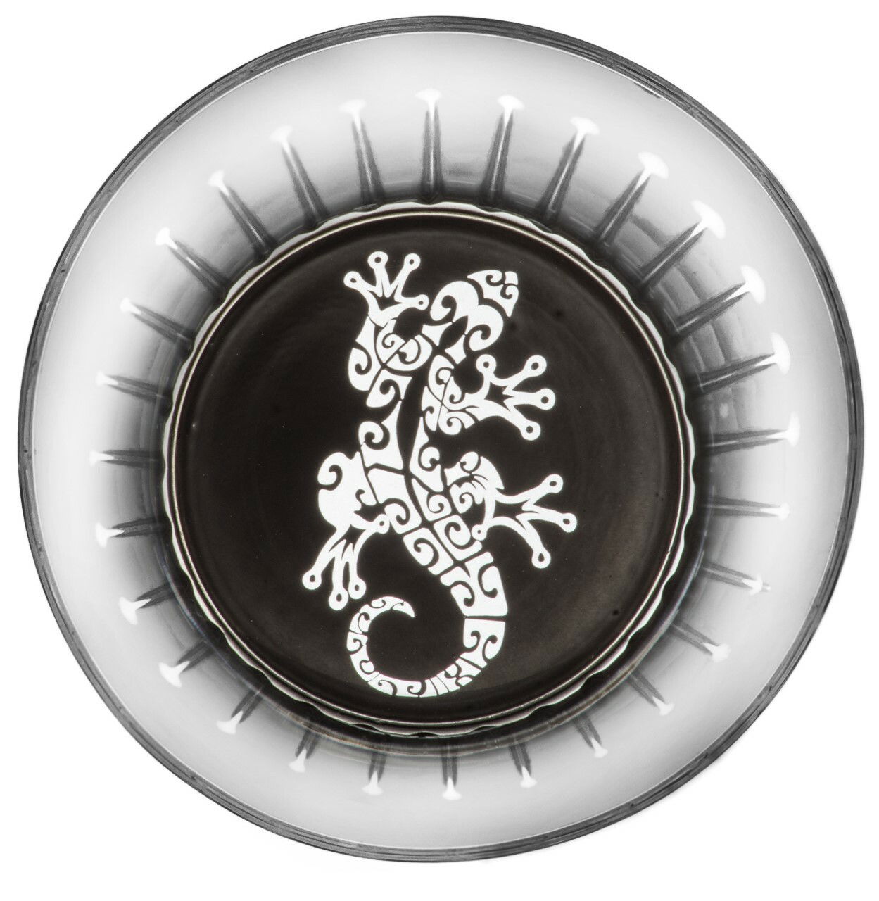 Ansicht von oben auf ein Glas mit Maori-Muster, das eine stilisierte Eidechse zeigt.