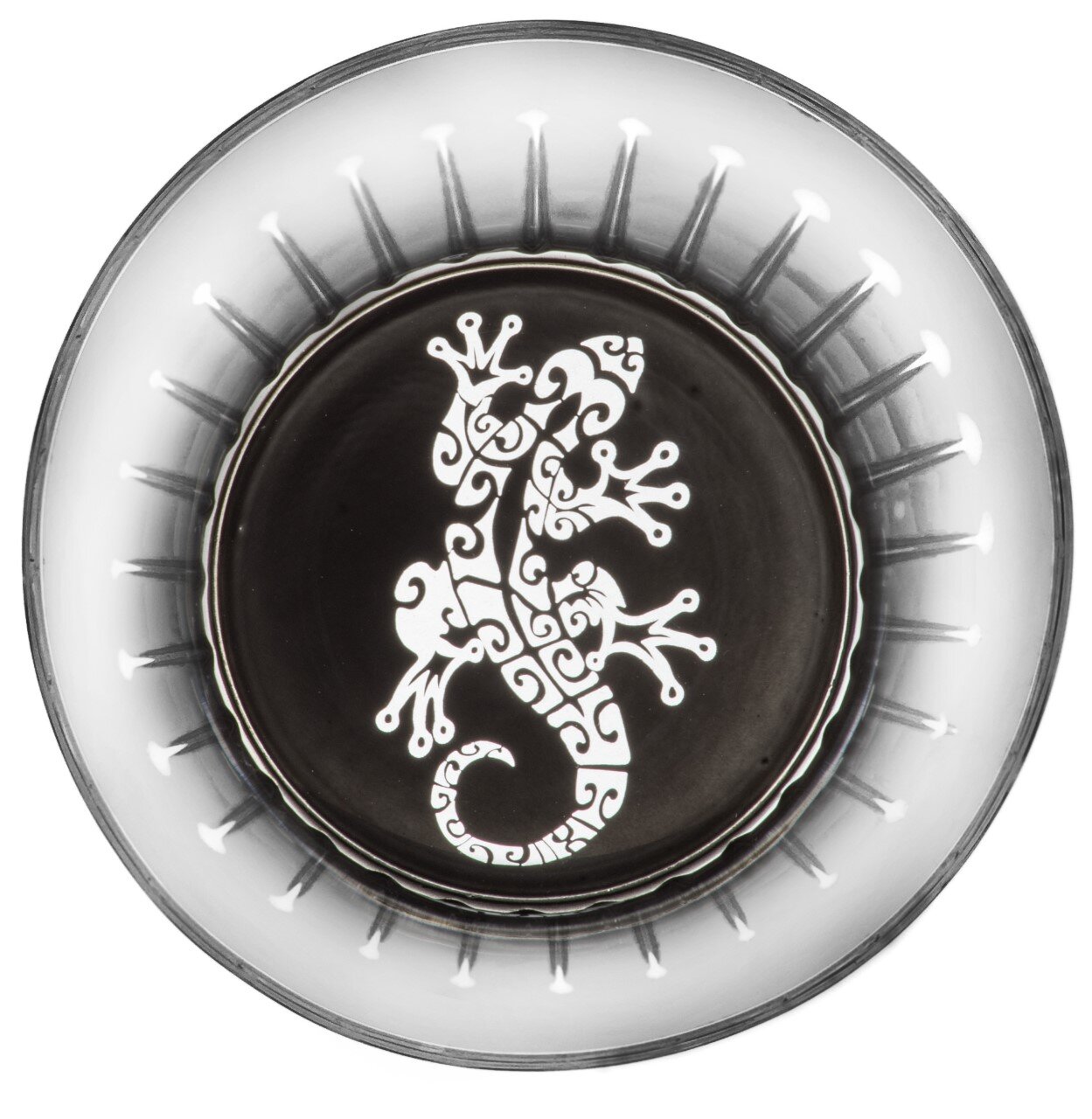 Ansicht von oben auf ein Glas mit Maori-Muster, das eine stilisierte Eidechse zeigt.