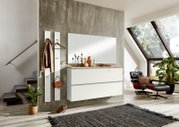 Moderner Hängeschuhschrank in einem stilvollen Wohnzimmer mit großem Fenster und gemütlichem Sessel, seitliche Perspektive