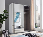 Moderner, zweitüriger Schwebetürenschrank mit Spiegel, teilweise geöffnet, in einem hellen Raum mit Blick auf die Stadt.