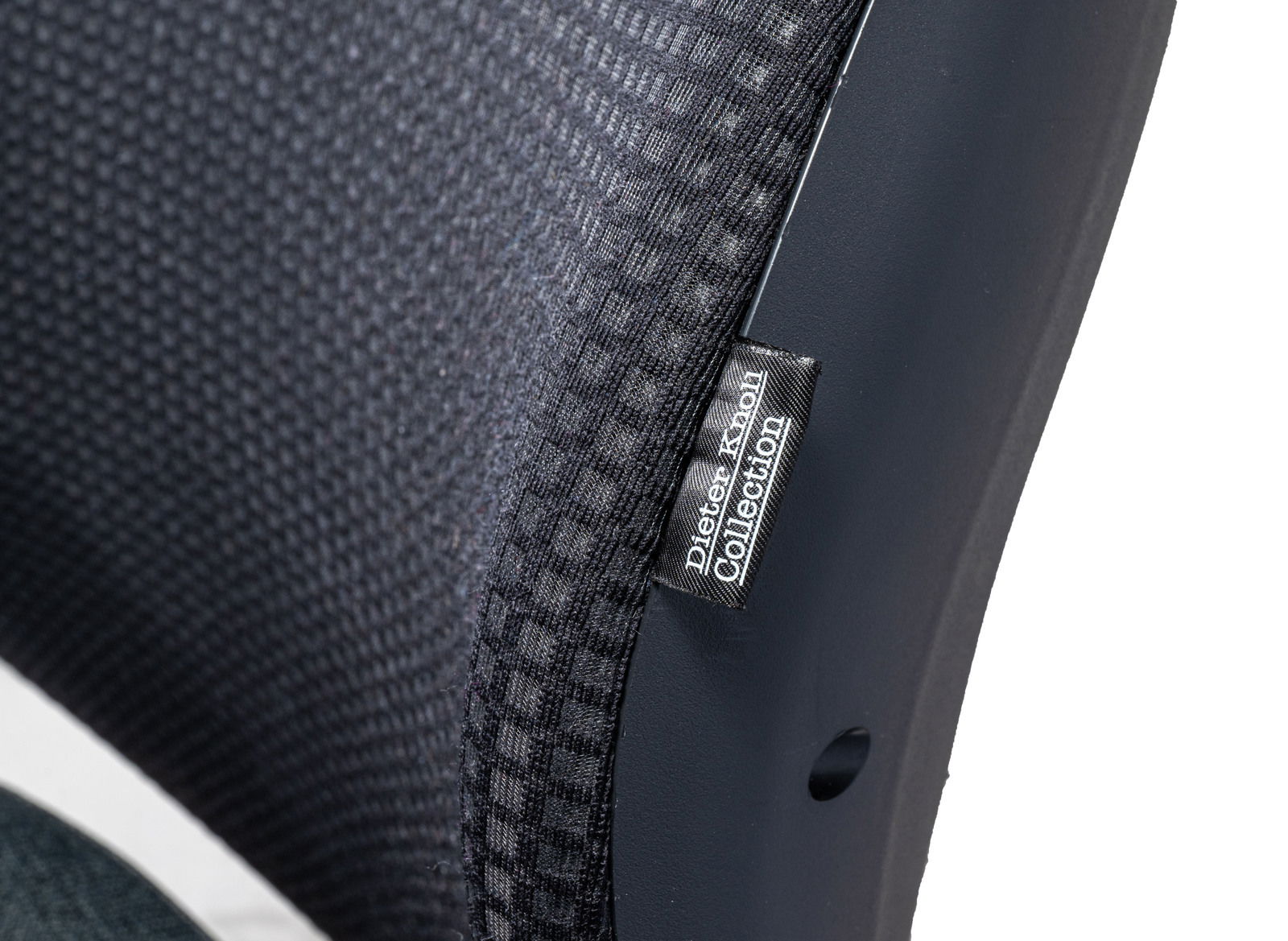 Nahaufnahme eines Drehstuhls aus der Dieter Knoll Collection, seitliche Perspektive auf die Rückenlehne mit schwarzem Stoffbezug.