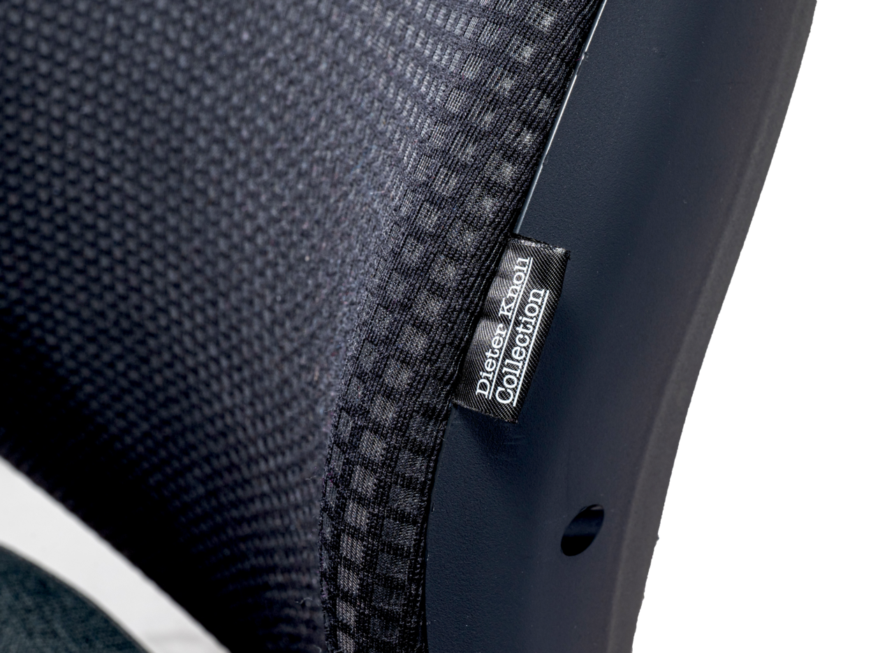 Nahaufnahme eines Drehstuhls aus der Dieter Knoll Collection, seitliche Perspektive auf die Rückenlehne mit schwarzem Stoffbezug.