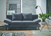Graues Querschläfer-Sofa in modernem Wohnzimmer, frontal betrachtet, mit Pflanzen und Stehlampe.