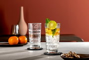 Zwei Longdrinkgläser SPIRITII 400ml auf einem Tisch, eines gefüllt mit einem Getränk, Eis, Limettenscheibe und Minze, aus seitlicher Perspektive fotografiert.