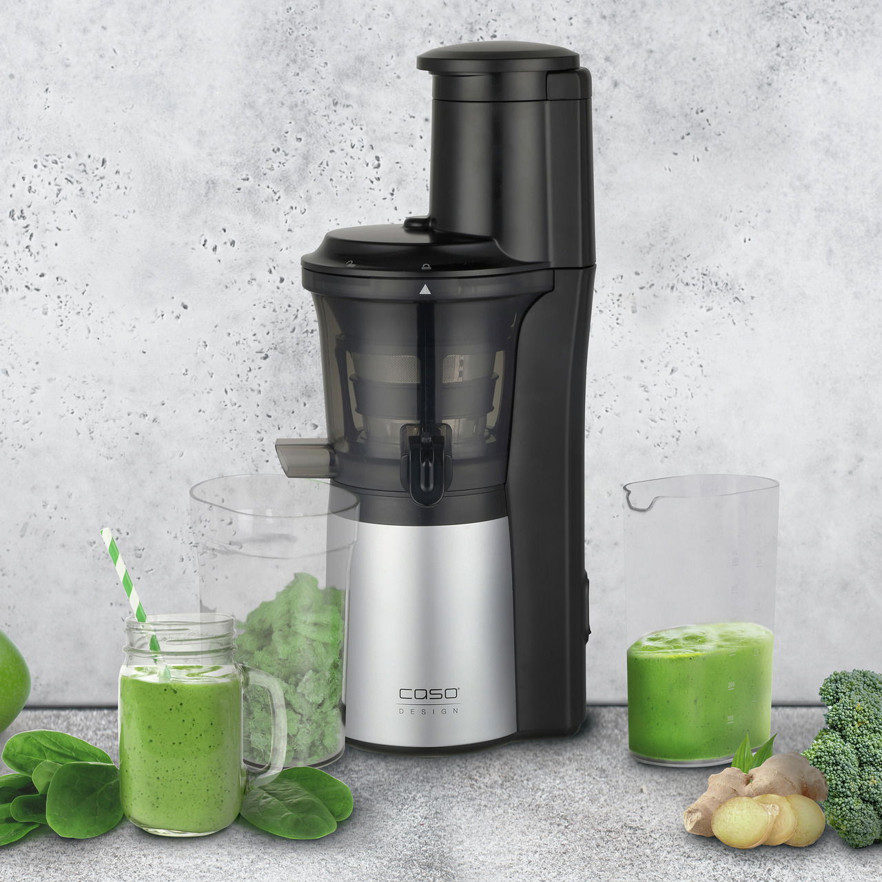 Slow Juicer in seitlicher Perspektive mit frischem grünem Saft und Zutaten wie Spinat, Apfel und Ingwer.