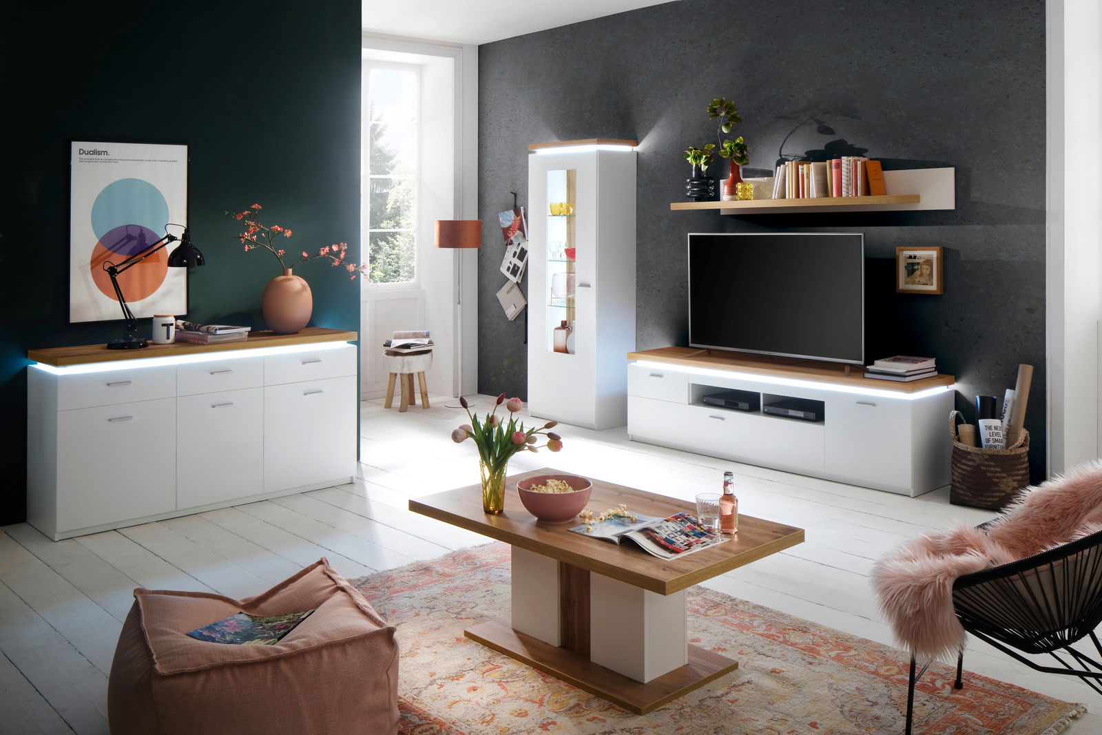 Moderne Wohnkombination in einem stilvollen Wohnzimmer mit weißem Sideboard, Vitrine und TV-Schrank, aus der Perspektive des Raumes betrachtet.