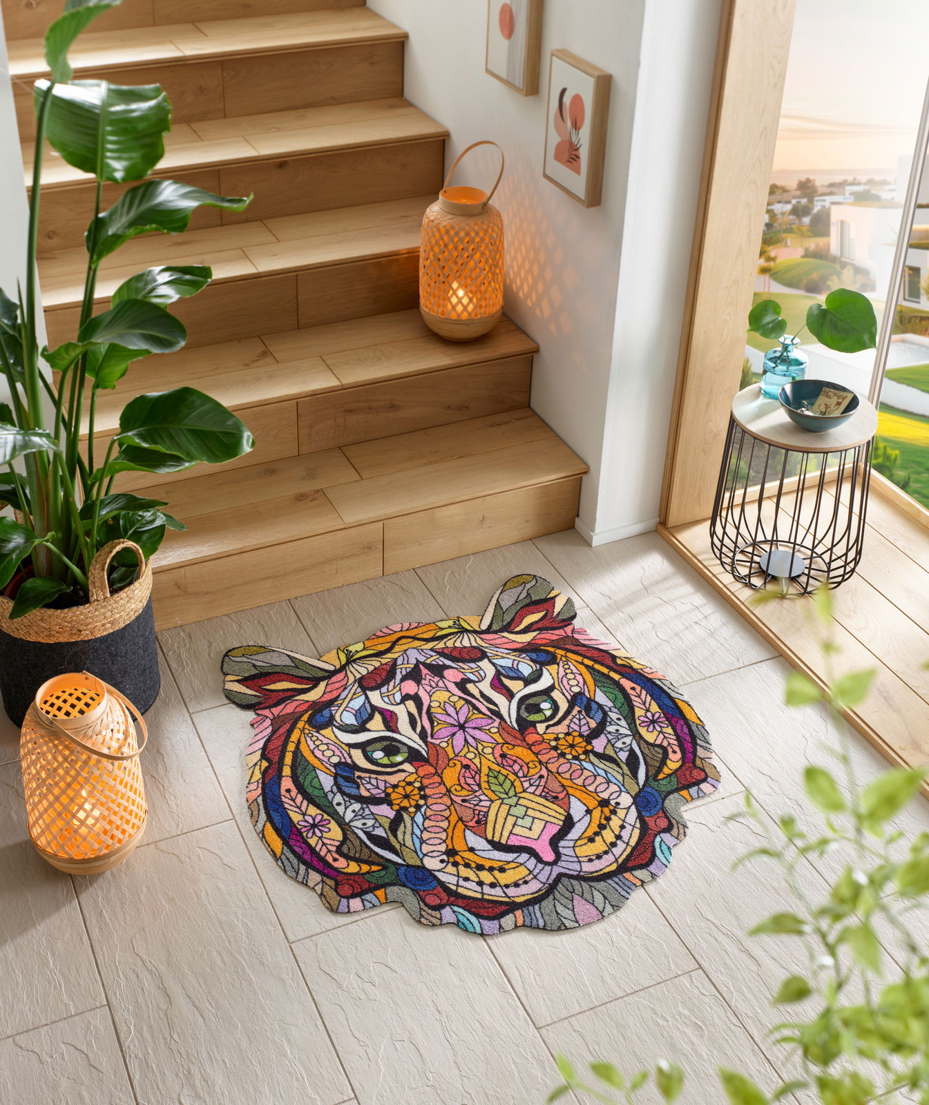 Bunte Fußmatte in Form eines Tigerkopfes mit abstraktem, geometrischem Design, platziert auf einem hellen Fliesenboden neben einer Holztreppe. Perspektive von oben.