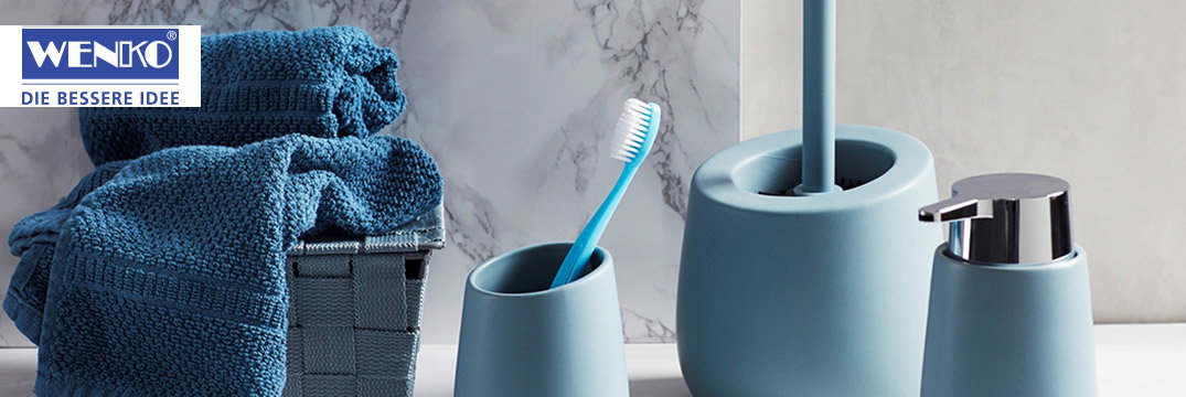 Blaue Bad-Accessoires mit Handtüchern, Zahnbürste, Seifenspender und WC-Bürste auf einer Marmorfläche.