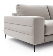 Nahaufnahme eines modernen, hellgrauen Longchairs mit eleganten, schwarzen Beinen. Perspektive von der Seite.