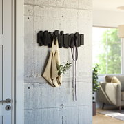 Moderne schwarze Wandgarderobe mit geometrischem Design, an der eine Tasche und ein Seil hängen. Perspektive von der Seite.